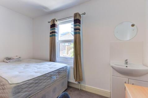 A simple and tidy bedroom featuring a single be...