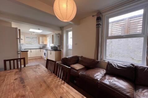 A cozy living room with a large brown leather s...
