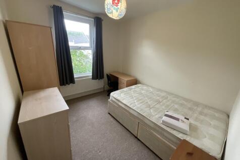 A neat and simple single bedroom with a well-ma...