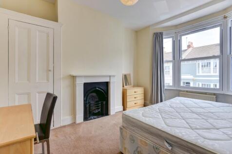 Bright master bedroom featuring a large bay win...