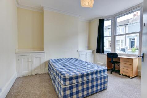 A bright single bedroom featuring a comfortable...