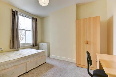 Bright and tidy bedroom featuring a large windo...