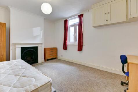 A bright and clean single bedroom featuring a w...