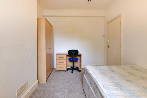 A neat and functional bedroom featuring a singl...