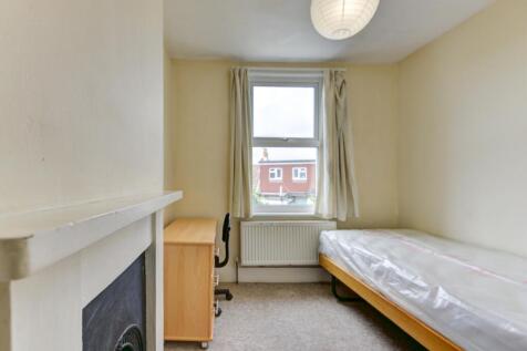 A cozy single bedroom featuring a comfortable b...
