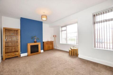 A bright and spacious living room featuring lar...