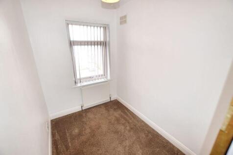 A small, clean room with a window featuring ver...