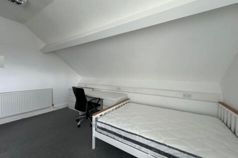 A clean and simple single bedroom featuring a w...