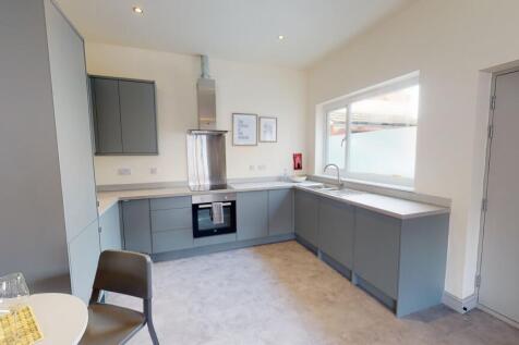 Modern, well-maintained kitchen with sleek grey...