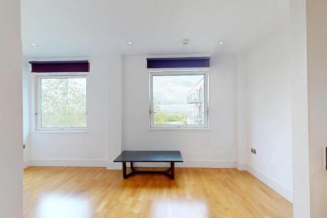 A bright, contemporary living room featuring tw...