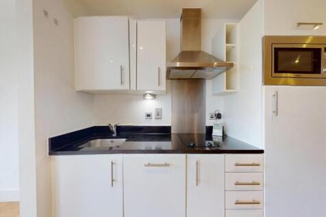 A modern and clean kitchen featuring white cabi...