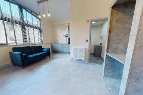 A spacious, well-lit contemporary living room w...
