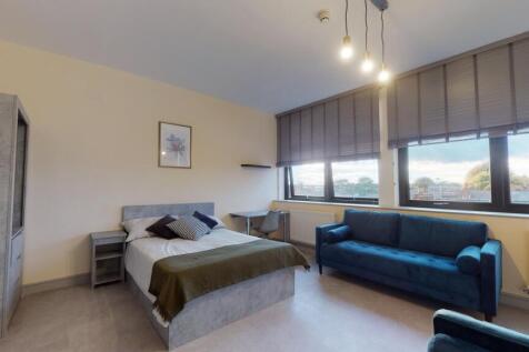 A spacious, well-lit living area featuring larg...