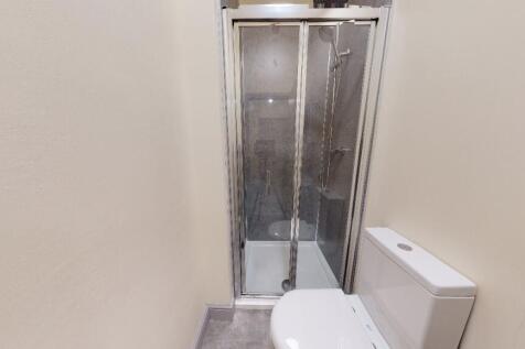 The bathroom features a modern enclosed shower ...