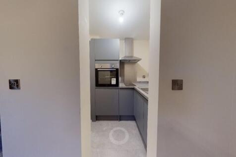 A modern, compact kitchen area featuring sleek ...