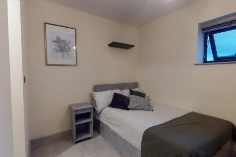 A cozy bedroom featuring a double bed with mult...