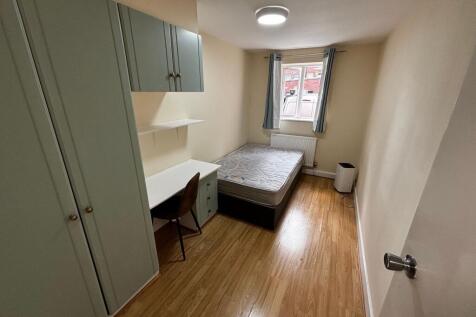 A cozy student bedroom featuring a single bed a...