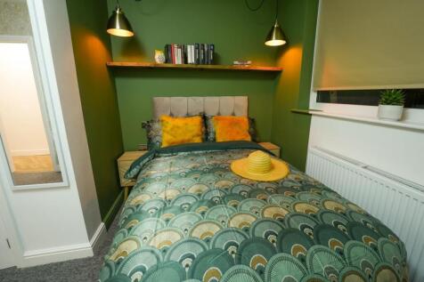 A modern bedroom featuring a cozy bed with deco...