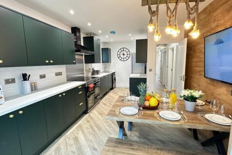 Modern kitchen featuring stylish cabinetry, amp...
