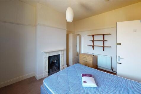 A bright double bedroom featuring a fireplace a...