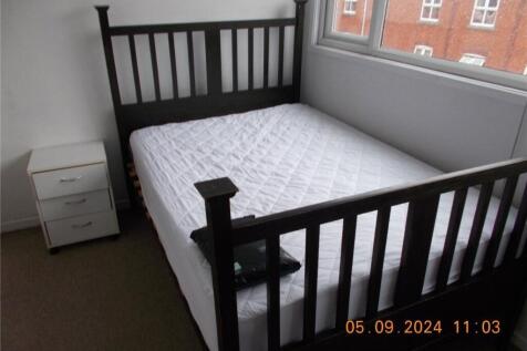 A bright double bedroom featuring a sleek black...