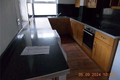 Modern kitchen featuring sleek black countertop...