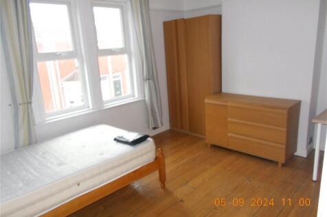 A bright and tidy single bedroom featuring a wo...