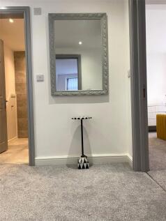 A neatly carpeted hallway featuring a large dec...