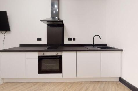 A modern, minimalist kitchen with sleek white c...