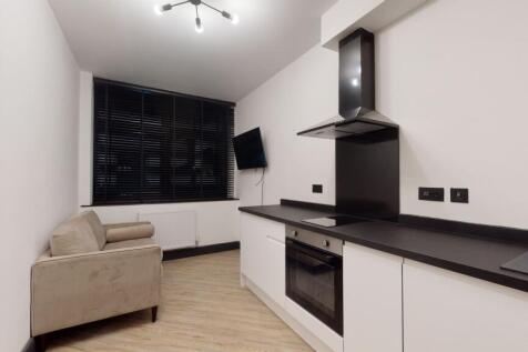 Modern kitchen area with white cabinetry, black...