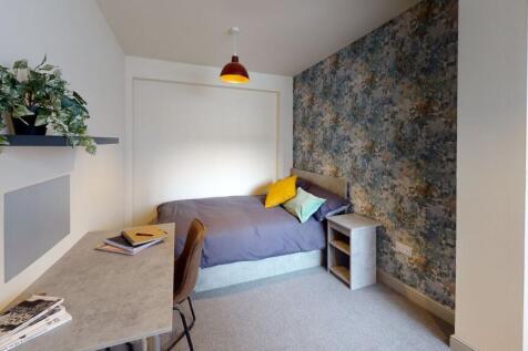 A cozy bedroom with a comfortable bed featuring...