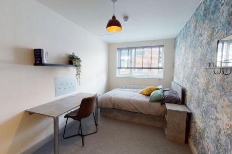 A cozy, well-lit bedroom featuring a comfortabl...