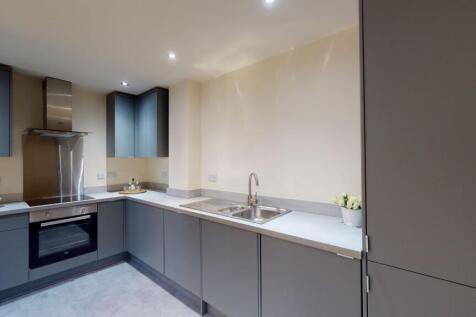 A modern kitchen featuring sleek gray cabinets,...