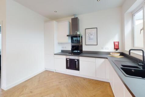Modern, bright kitchen with white cabinetry, bl...