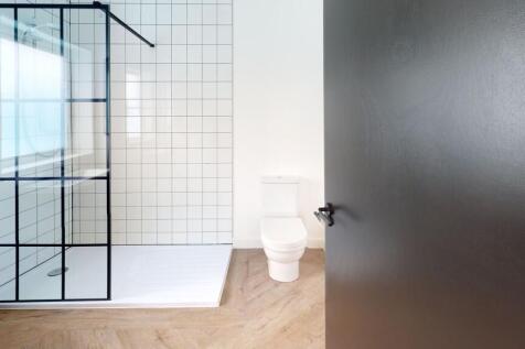 Modern bathroom featuring a spacious shower enc...