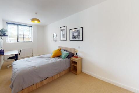 A bright and welcoming master bedroom with a la...
