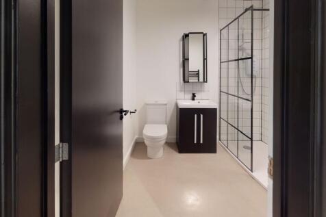 Modern bathroom featuring a white toilet, a sle...