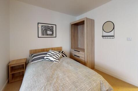 A cozy, well-maintained bedroom featuring styli...