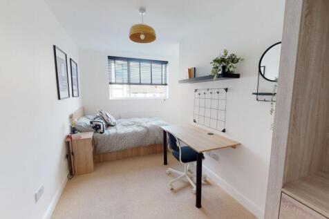 A bright, modern bedroom featuring a comfortabl...