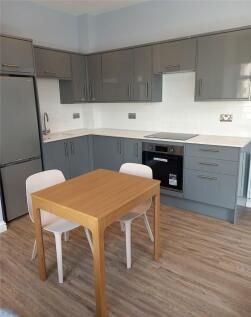 A modern kitchen with sleek grey cabinets, inte...