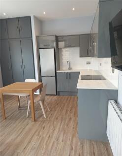 A modern kitchen featuring sleek grey cabinetry...