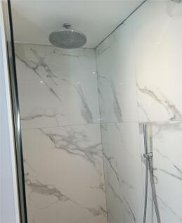 A modern bathroom shower area featuring elegant...