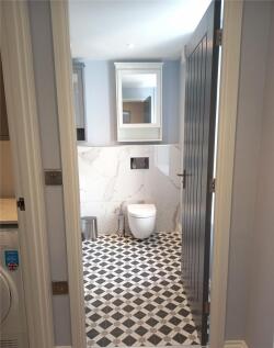 A modern bathroom suite featuring patterned flo...