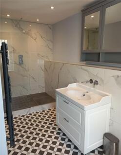 A modern bathroom featuring a spacious walk-in ...