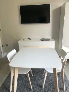 A modern communal lounge featuring a clean whit...