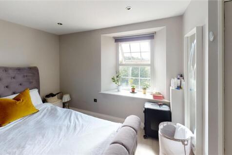 A cozy double bedroom with a comfortable uphols...