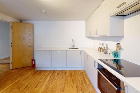 Bright and modern kitchen with white cabinetry,...