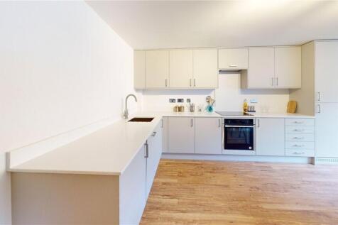 Modern, bright kitchen featuring sleek white ca...