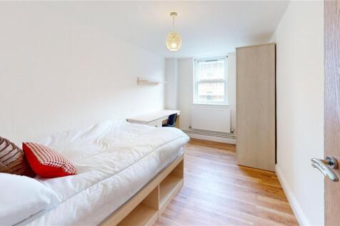Bright and cozy bedroom featuring a neatly made...
