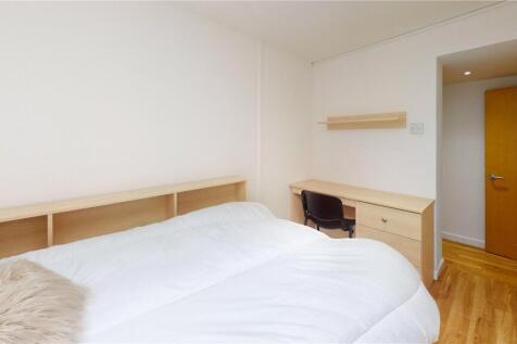 A bright and clean bedroom featuring a neatly m...